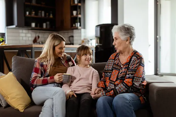 Tři Generace Žen Užívají Smích Konverzaci Pohodlném Gauči Obývacím Pokoji — Stock fotografie