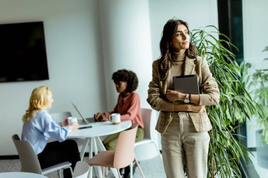 Değişik bir grup insanın önünde duran kendine güvenen bir kadın liderlik, güç ve birlik sergiliyor..