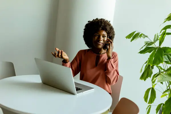 Selbstbewusste Frau Mit Telefon Und Laptop Einem Hellen Mit Pflanzen — Stockfoto