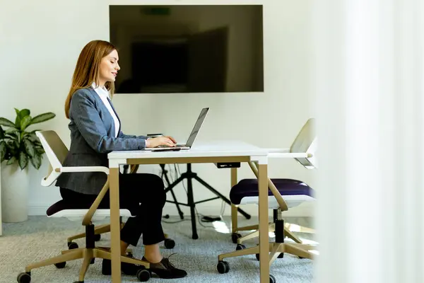 Dalmış Bir Kadın Masada Oturuyor Dizüstü Bilgisayar Kullanıyor — Stok fotoğraf