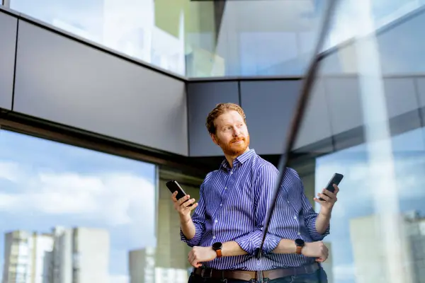 Uomo Concentrato Una Camicia Righe Parla Sul Suo Telefono Mentre Immagine Stock