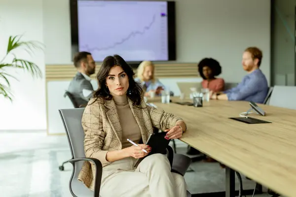 Focused Businesswoman Notepad Ponders Team Meeting Colleagues Engaged Discussion Background Stock Image