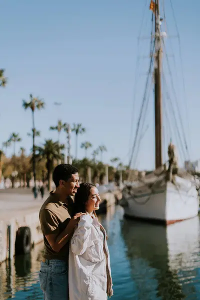 Pasangan Muda Merangkul Sambil Menjelajahi Suasana Pantai Yang Mempesona Dari Stok Gambar Bebas Royalti