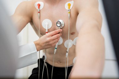 Odaklanmış bir birey, izleme ekipmanlarıyla bağlantılı bir koşu bandında stres testi yapar..