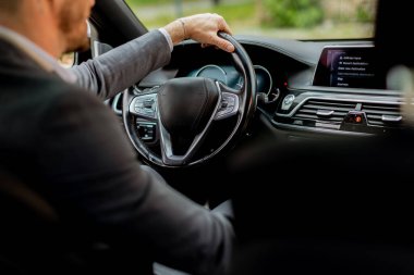 Neşeli sürücü direksiyonu tutarken gülümser, iyi donanımlı bir araçla yolda ilerler.