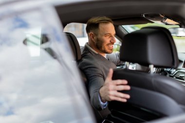 İnsan, parlak sedanında kendisine katılması için birini çağırırken mutlulukla ışıldar.