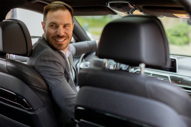 İnsan, parlak sedanında kendisine katılması için birini çağırırken mutlulukla ışıldar.