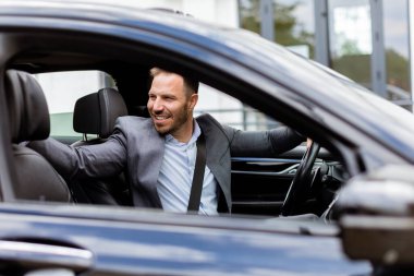 İnsan, parlak sedanında kendisine katılması için birini çağırırken mutlulukla ışıldar.