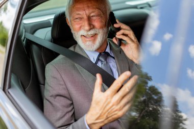 Rahat bir araba yolculuğunda, tatlı yaşlı adam cep telefonuyla sohbet eder. Cazibesi ve kendine güveni vardır.