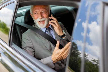 Rahat bir araba yolculuğunda, tatlı yaşlı adam cep telefonuyla sohbet eder. Cazibesi ve kendine güveni vardır.