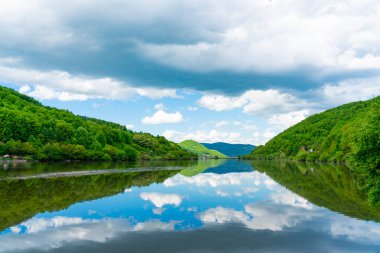 Porec Körfezi 'nin sakin suları, Sırbistan' ın barışçı Tuna Vadisi 'ndeki yuvarlanan tepelerle çevrili canlı yeşil ve mavi gökyüzünü yansıtıyor