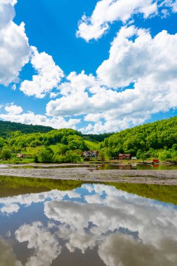 Porec Körfezi 'nin sakin suları, Sırbistan' ın barışçı Tuna Vadisi 'ndeki yuvarlanan tepelerle çevrili canlı yeşil ve mavi gökyüzünü yansıtıyor
