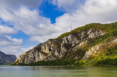 Sırbistan 'daki Tuna Vadisi' nin çarpıcı manzarası dramatik uçurumları, yemyeşil ve sakin suları gözler önüne seriyor. Sonbahar renkleri sahneye sıcaklık katar, huzurlu ve resimsel bir manzara yaratır.