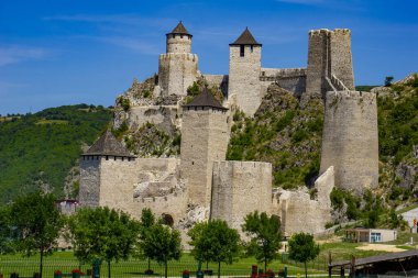 Antik Golubac Kalesi gür yeşilliklerin ortasında dimdik duruyor, taş kulelerinin ve duvarlarının ihtişamını Sırbistan 'da canlı, bulutsuz bir gökyüzüne karşı sergiliyor