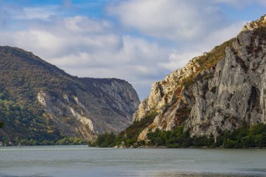 Sırbistan 'daki Tuna Vadisi' nin çarpıcı manzarası dramatik uçurumları, yemyeşil ve sakin suları gözler önüne seriyor. Sonbahar renkleri sahneye sıcaklık katar, huzurlu ve resimsel bir manzara yaratır.