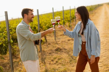 Batan güneşin sıcacık parıltıları altında, birkaç çift, üzüm bağlarında şarap yudumlarken kahkahalarını paylaşıyor, üzüm bağlarının arasında sevgi dolu anılar yaratıyor.