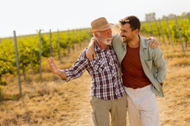 Güneşli bir üzüm bağında tozlu bir yolda yürürken, iki adam açık yürekli bir sohbete girişir, dostlukları, yayılan üzümlerin arka planına karşı aşikardır.