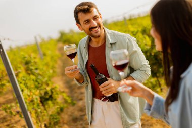 Batan güneşin sıcacık parıltıları altında, birkaç çift, üzüm bağlarında şarap yudumlarken kahkahalarını paylaşıyor, üzüm bağlarının arasında sevgi dolu anılar yaratıyor.