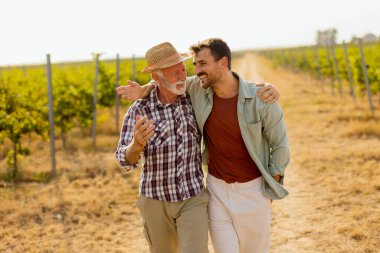 Güneşli bir üzüm bağında tozlu bir yolda yürürken, iki adam açık yürekli bir sohbete girişir, dostlukları, yayılan üzümlerin arka planına karşı aşikardır.