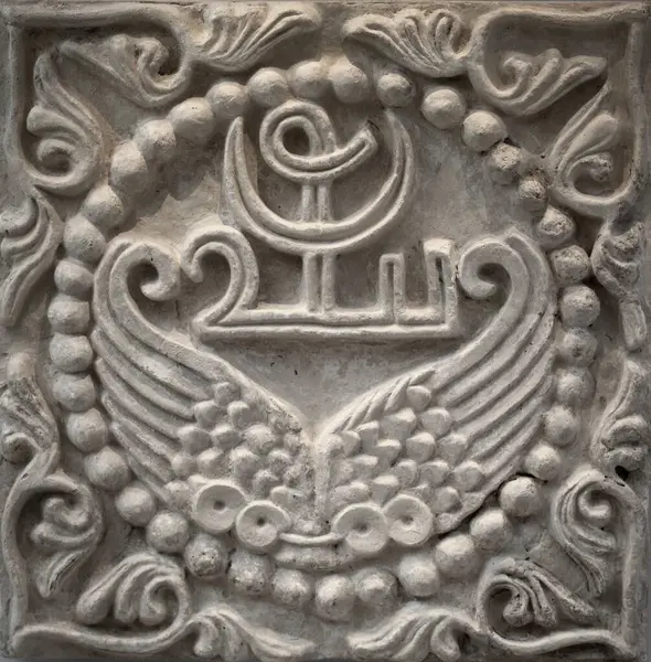 stock image Stucco relief wall panel showcases the artistry of the 6th century Sasanian period of Mesopotamia, adorned with wings and a unique Pahlavi device encircled by elegant pearls