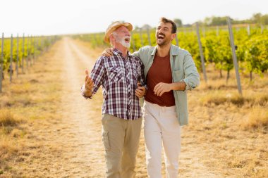 Güneşli bir üzüm bağında tozlu bir yolda yürürken, iki adam açık yürekli bir sohbete girişir, dostlukları, yayılan üzümlerin arka planına karşı aşikardır.
