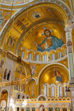 Belgrad, Sırbistan - 29 Nisan 2024: Belgrad 'daki Saint Sava Kilisesi' nin içi, parlak kemerli bir tavan altında dini simgeler tasvir eden ayrıntılı altın mozaiklerle süslenmiş. Sırp Ortodoks Kilisesi 'nin ana katedrali