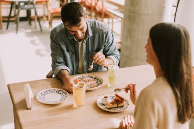 İki arkadaş, keyifli bir brunch 'ın keyfini çıkarırken aynı zamanda nefis yemeklerin ve renkli içkilerin tadını çıkarıyorlar..