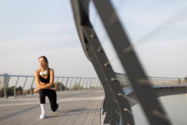 Sabah ışığında, kendini adamış genç bir kadın zarif bir şehir köprüsünde hareketli bir hareket sergiliyor, azim ve zarafetle yeni bir günün tazeliğini kucaklıyor..