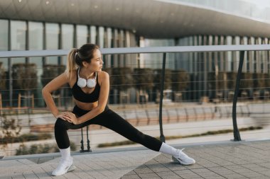 Kendini adamış bir birey, parlak bir mimariyle çevrili yüksek bir yolda, güneş batarken, hayat dolu, sağlık odaklı bir yaşam tarzını somutlaştıran esnek bir rutin gerçekleştirir..