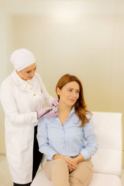 A skilled medical professional performs an electrocautery procedure on a smiling patient. The calm ambiance and attentive care highlight the importance of effective wart removal. clipart