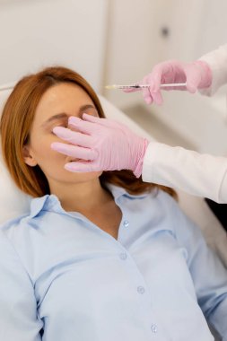 A client enjoys a dermal filler botox treatment in a modern clinic, as a skilled professional carefully administers the injections, fostering an atmosphere of relaxation and renewal. clipart