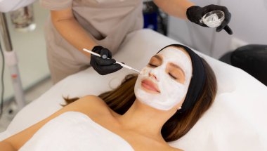 Sakin bir spa ortamı, yetenekli bir teknisyenin müşterinin yüzüne rahatlatıcı bir maske takarak doğal güzelliğini ve rahatlığını arttırdığı mükemmel bir atmosfer sağlar..