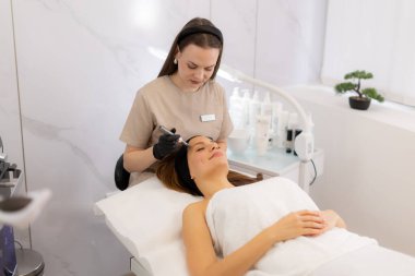 Yetenekli bir pratisyen, müşterinin derisini canlandırmak için mikro terapi aleti kullanır. Huzurlu güzellik kliniği atmosferi dönüştürücü tedavi deneyimini tamamlıyor.