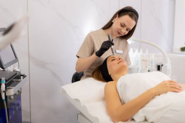 Yetenekli bir pratisyen, müşterinin derisini canlandırmak için mikro terapi aleti kullanır. Huzurlu güzellik kliniği atmosferi dönüştürücü tedavi deneyimini tamamlıyor.