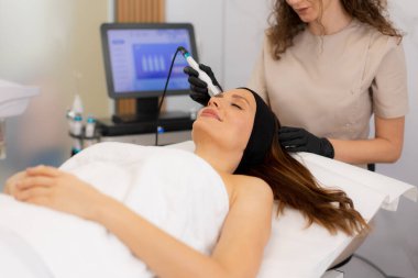 Becerikli bir pratisyen, sağlıklı bir spanın iyileştirici atmosferinin keyfini çıkaran rahat bir müşteri için gözenek temizleme ve sıvı alma üzerine odaklanarak canlandırıcı bir cilt bakımı uygular..