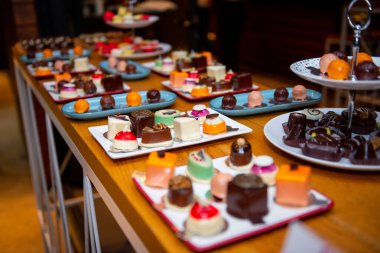 A colorful array of artisan chocolates is elegantly presented on a stylish plate during a joyful confectionery event. Each piece is crafted with unique flavors and artistic designs. clipart