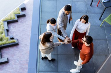 Beş arkadaş coşkulu bir grup olarak el sıkışır, dostluklarını ve takım çalışmalarını sergilerler. Atmosfer parlak ve canlı. Şehirdeki açık hava buluşmaları için mükemmel..