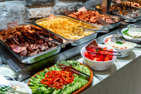 A vibrant buffet showcases a variety of grilled meats, fresh salads, and crispy side dishes, inviting guests to indulge in a feast of flavors and textures.