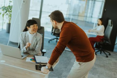 Meslektaşlar projeyi parlak, çağdaş bir ofis alanında tartışırlar. Bir ortak hevesle hareket ederken, diğeri notlar alıp, takım çalışması ve işbirliği sergiliyor.