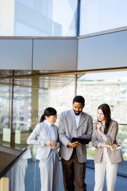 Üç meslektaş, belgelere parlak ve çağdaş bir çalışma alanında göz atarken dinamik bir tartışmaya girişirler. Güneş ışığı büyük cam pencerelerden süzülerek davetkar bir atmosfer yaratır..