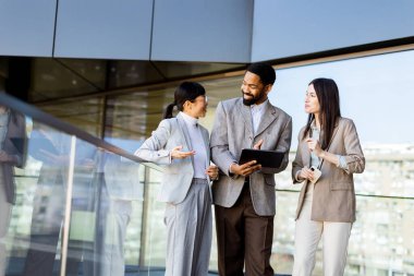 Üç meslektaş, belgelere parlak ve çağdaş bir çalışma alanında göz atarken dinamik bir tartışmaya girişirler. Güneş ışığı büyük cam pencerelerden süzülerek davetkar bir atmosfer yaratır..