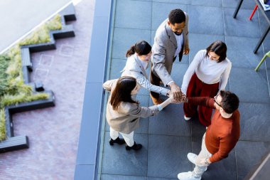 Beş arkadaş coşkulu bir grup olarak el sıkışır, dostluklarını ve takım çalışmalarını sergilerler. Atmosfer parlak ve canlı. Şehirdeki açık hava buluşmaları için mükemmel..