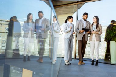 Şık giyinmiş beş profesyonelden oluşan bir grup, çağdaş bir ofis alanında canlı bir tartışmaya girişiyor. Tabletleri tutarlar ve gülümserler, şehrin ufuk çizgisi camlara yansır..