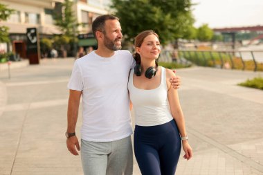 Odaklanmış bir adam öğleden sonra saatlerinde nehir kenarında egzersiz yaparken sudan zevk almak için duraksar.