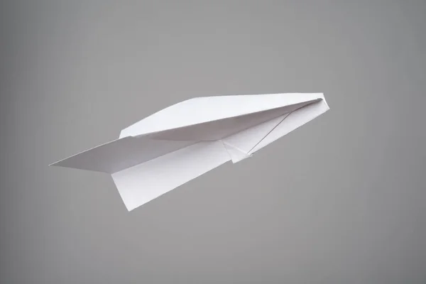 灰色の背景に白い小さな紙飛行機 — ストック写真