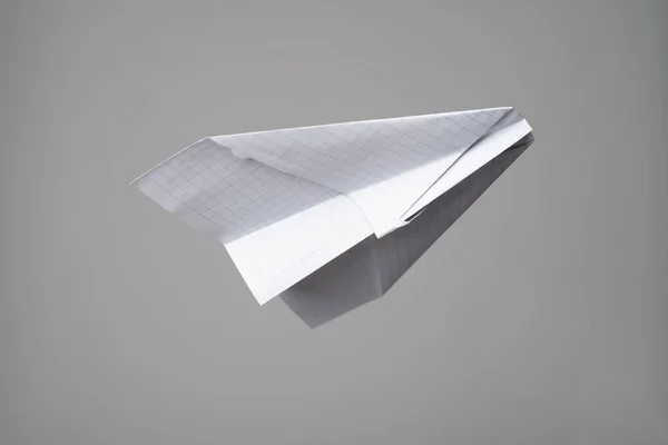 灰色の背景に小切手紙で作られた折り紙飛行機 — ストック写真