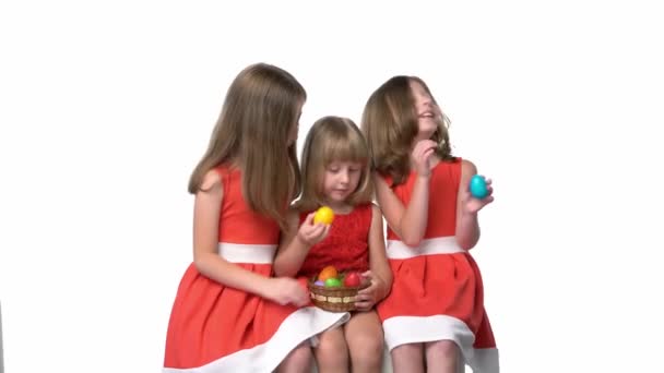 Tiga Anak Dalam Gaun Merah Bermain Dengan Telur Paskah Latar — Stok Video