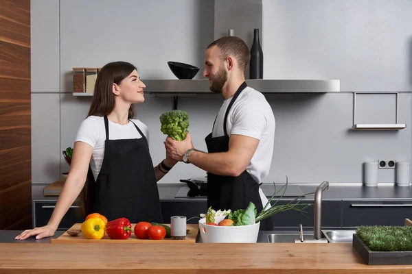 Pasangan Muda Coocking Salad Dapur Modern Melihat Satu Sama Lain — Stok Foto