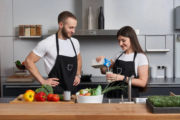 Young Couple Coocking Salad Modern Kitchen Girl Pouring Milk Glass — Stock Photo, Image