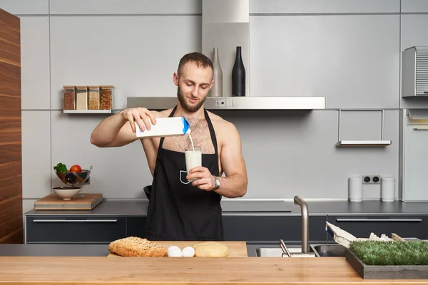 Pria Berotot Tak Berbaju Mengenakan Celemek Koki Menuangkan Susu Dalam — Stok Foto